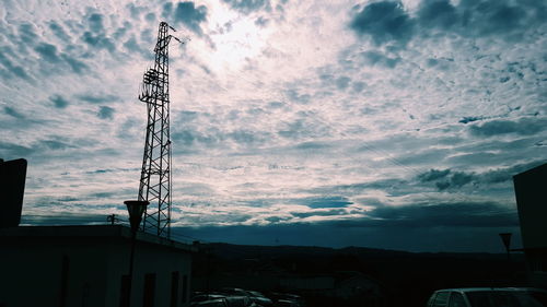 Low angle view of power lines against cloudy sky