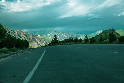 Empty road leading towards mountains