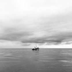 Boat sailing on sea against sky