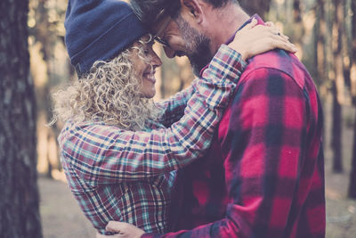 Happy couple standing in forest