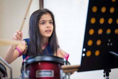 Girl in sari playing drum