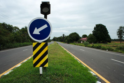 Road sign against sky