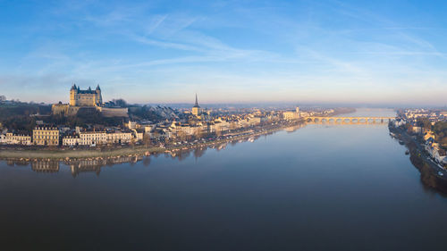 Saumur skyline with medieval castle, saint peter church and river at sunrise, loire valley, france