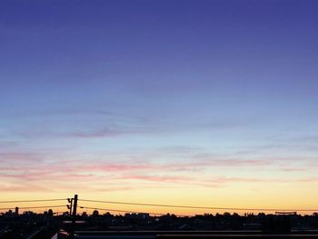 Silhouette city against sky during sunset