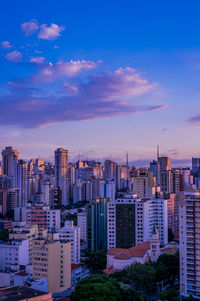 Buildings in city against sky during sunset