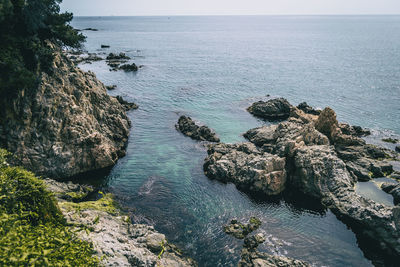 High angle view of rocks in sea against sky