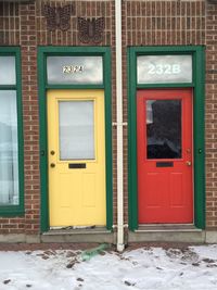 Closed red and yellow doors on brick wall