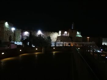 Illuminated cityscape against sky at night
