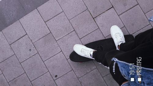 Low section of person standing on tiled floor