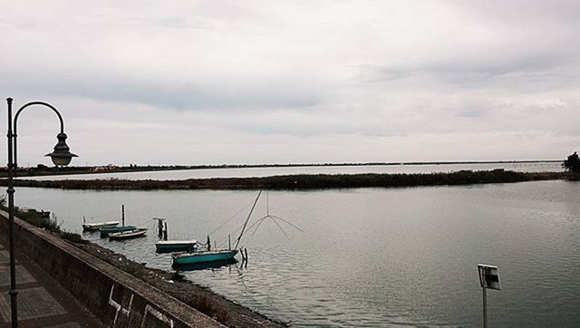 water, sky, tranquility, sea, tranquil scene, nautical vessel, scenics, transportation, nature, beauty in nature, cloud - sky, lake, pier, boat, mode of transport, idyllic, street light, cloudy, outdoors, calm