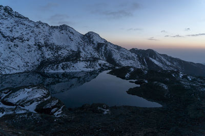 Scenic view of snowcapped mountains against sky during sunset