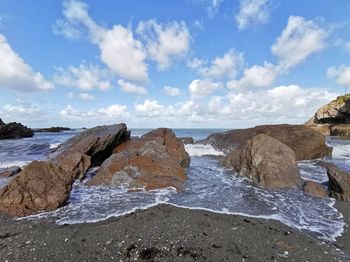 Rocks on beach against sky