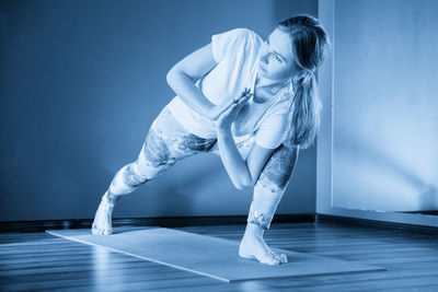 Side view of woman exercising in gym