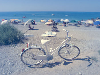 Bicycles on beach against sky