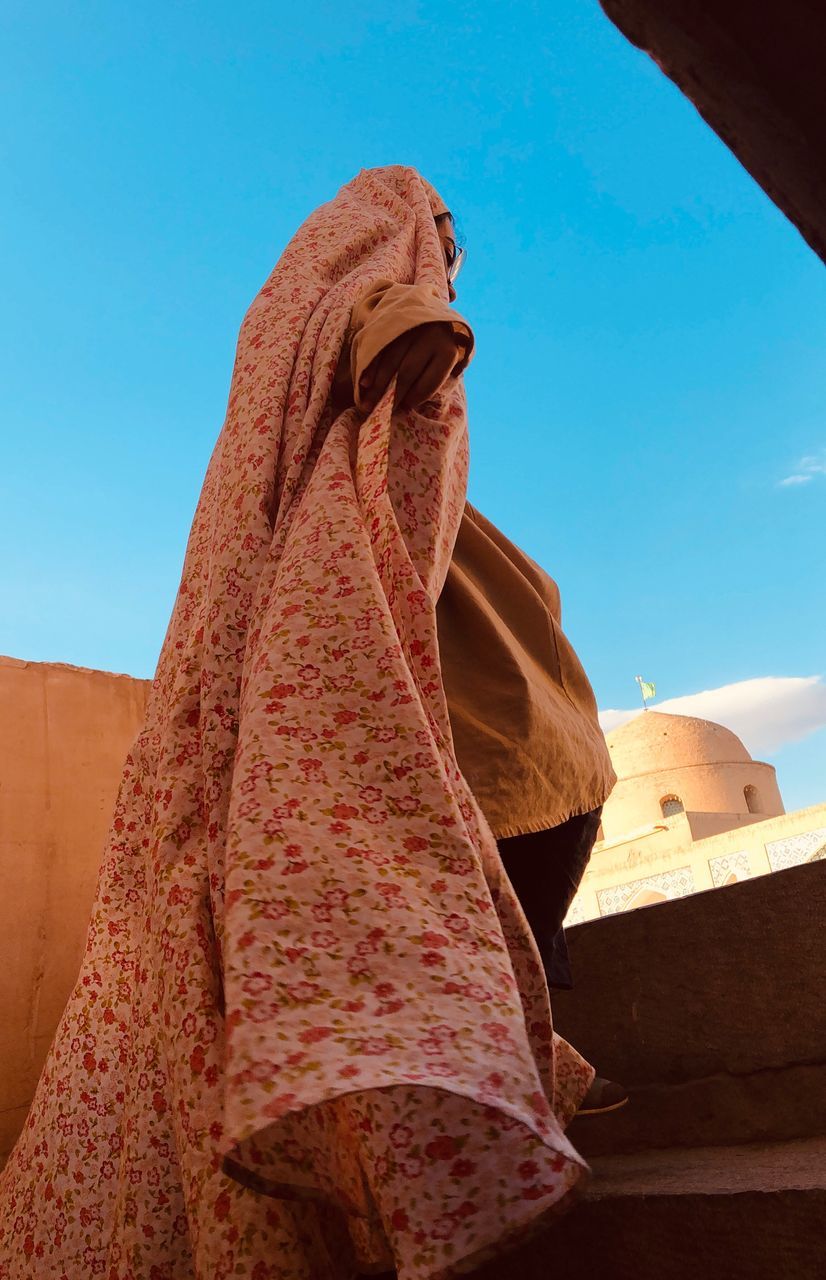 LOW ANGLE VIEW OF WOMAN AGAINST SKY