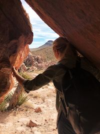 Woman looking out of a cave in red rock canyon, las vegas, nevada. travel concept adventure concept