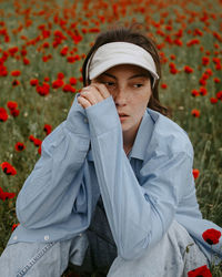Portrait of young woman standing amidst plants