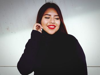 Close-up of young woman against white background