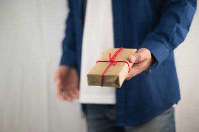 Midsection of man holding umbrella in box