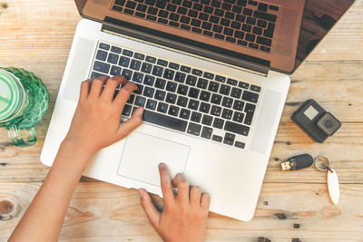 Midsection of woman using mobile phone on table