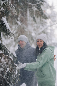 Happy couple playing winter game in forest outdoors. love and leisure concept.