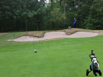 Man with umbrella on golf course