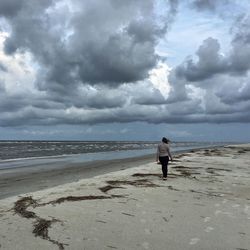 Rear view of man walking on beach