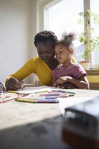 Mother and daughter drawing together