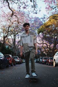 Portrait of young woman standing against trees