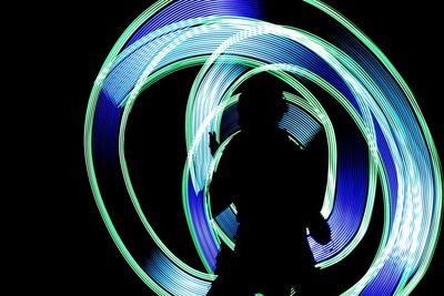 Silhouette man and light trails at night