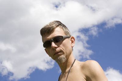 Low angle portrait of mature man against sky