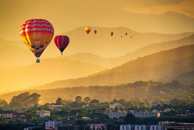 Hot air balloons flying against sky during sunset