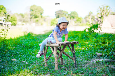 Boy sitting on grass against plants