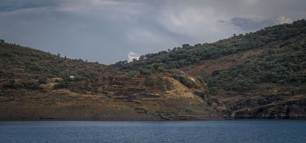 Scenic view of river and mountains against sky