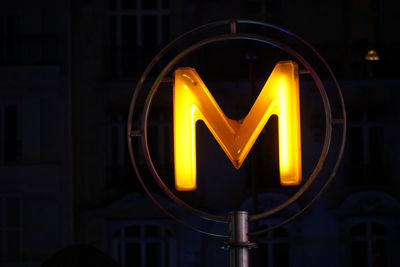 Sign of subway station in a street at night in paris, france