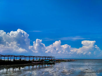 Pier over sea against blue sky