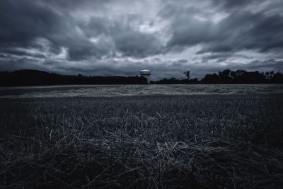 Scenic view of field against cloudy sky