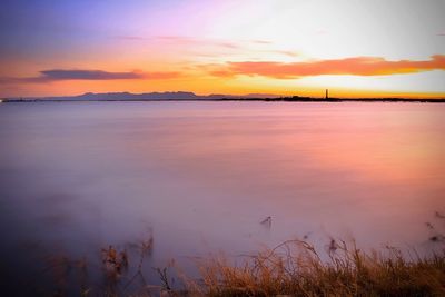 Scenic view of sea against romantic sky at sunset