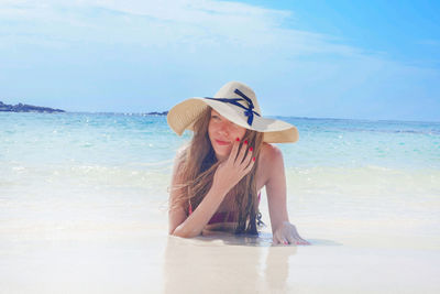 Rear view of young woman in sea against sky