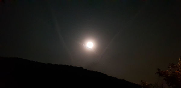 Low angle view of silhouette moon against sky at night