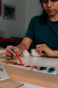 Unfocused latin woman preparing color palette for painting