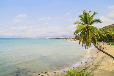 Scenic view of beach against cloudy sky