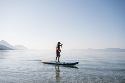 Full length of man in sea against clear sky