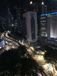 High angle view of illuminated street amidst buildings at night