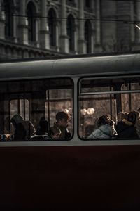 People at railroad station platform seen through window