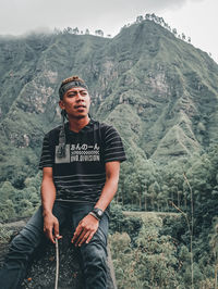 Portrait of young man standing on mountain