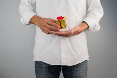 Midsection of man holding hands against white background