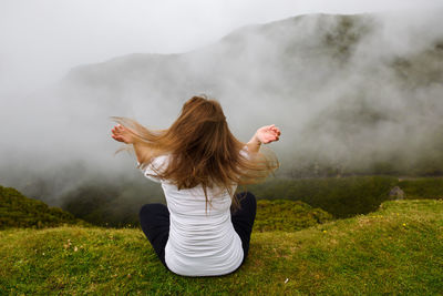 Rear view of woman on field against sky