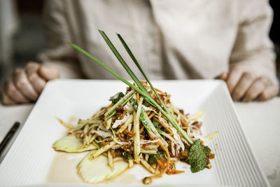 Close-up of hand in plate on table