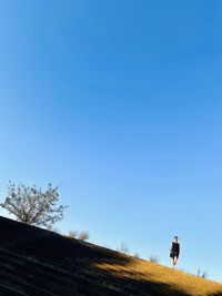 Low angle view of woman walking on steps against sky
